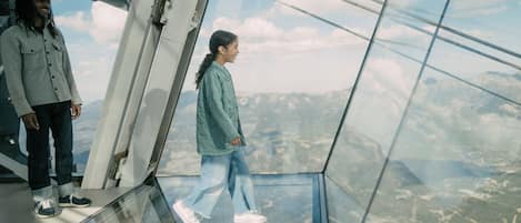 A glass floor with a view of a mountainous landscape.