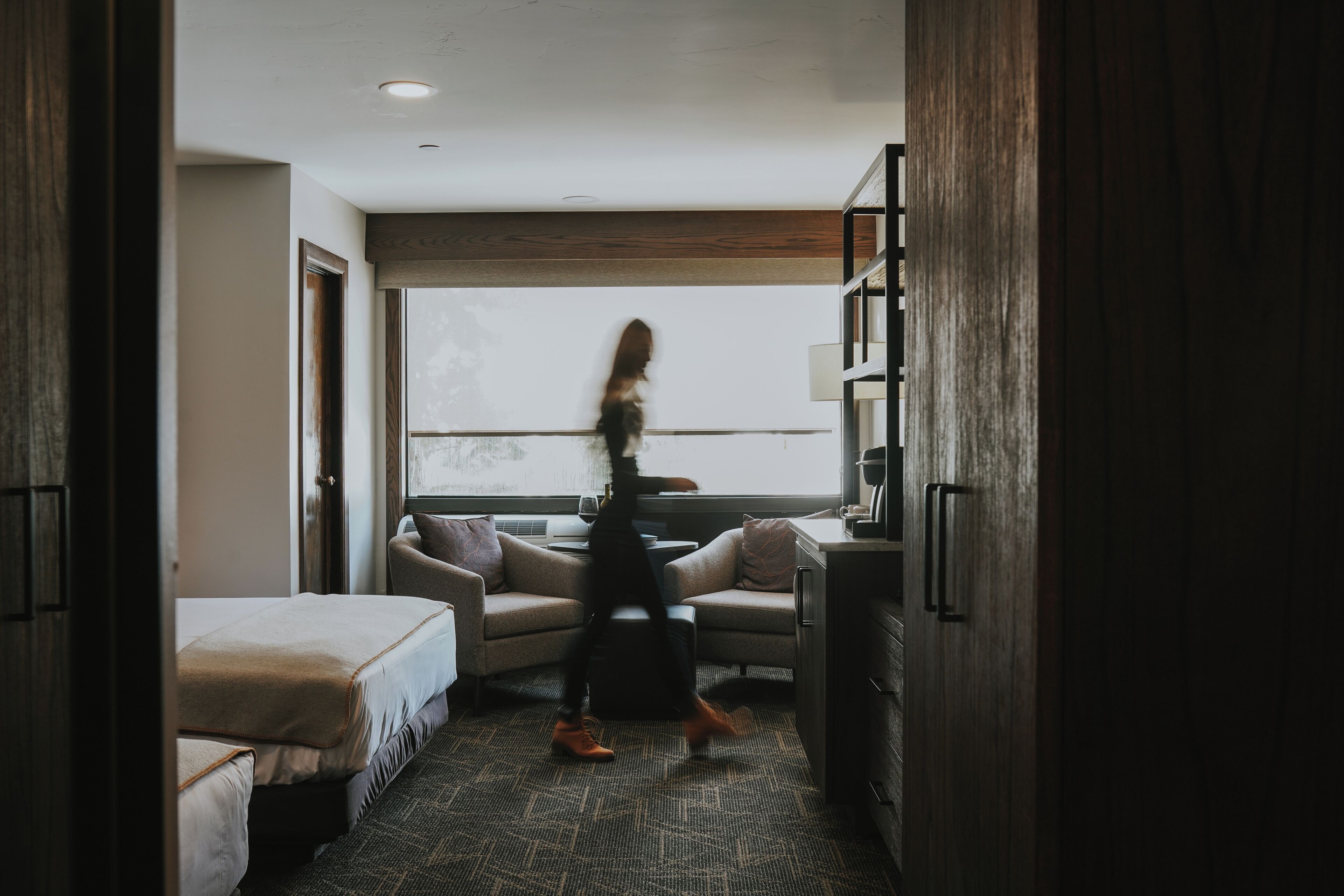 Een hotelkamer met een bed, een bank, een bureau en een raam.