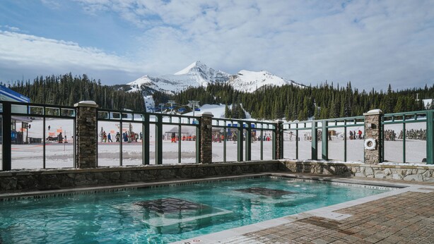 Un espace piscine offrant une vue sur une montagne enneigée.