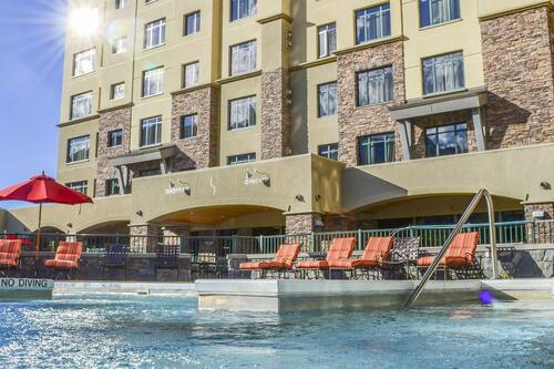 Una piscina al aire libre, sombrillas, tumbonas
