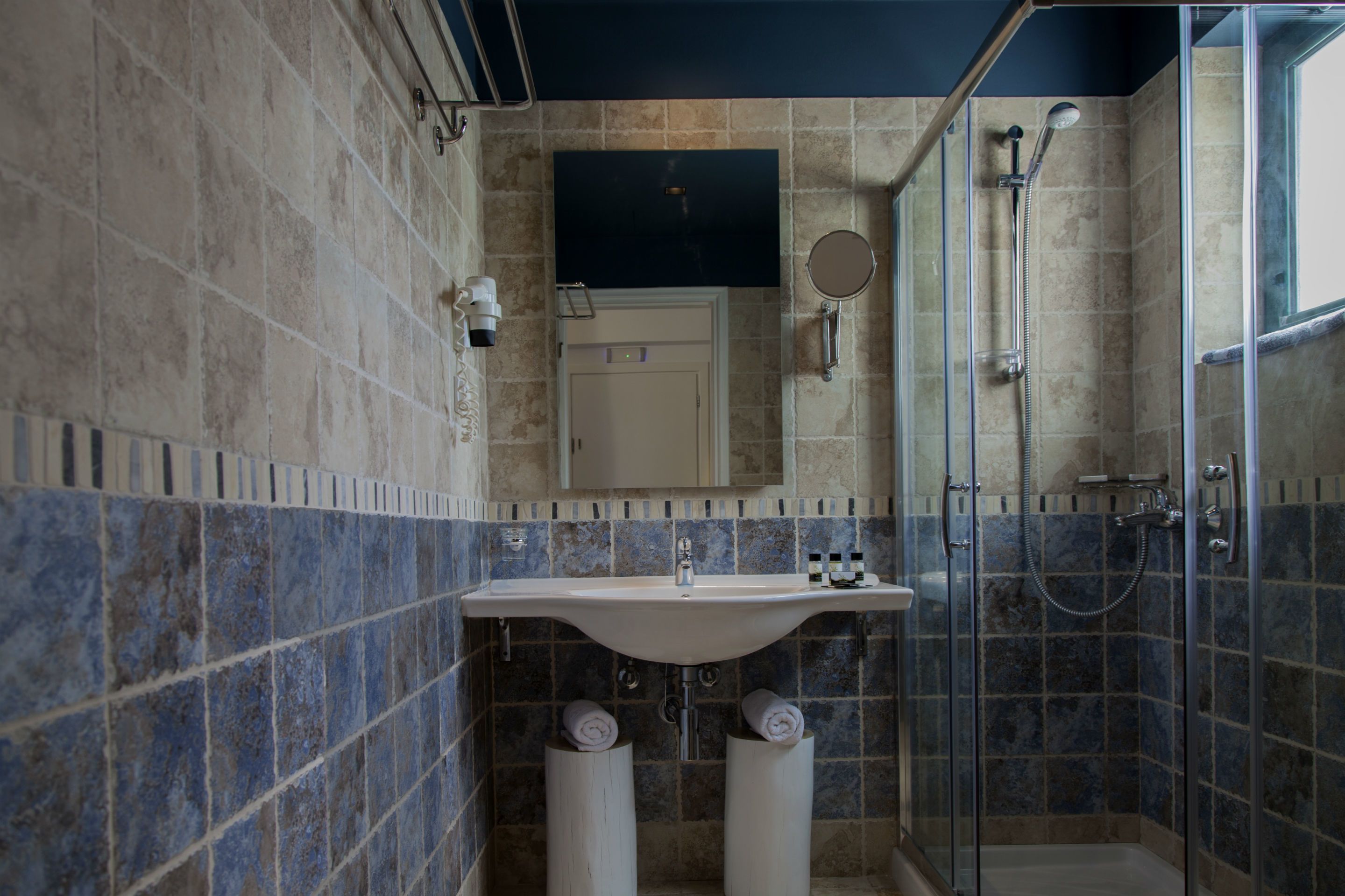 Un bagno con lavandino, specchio e doccia.