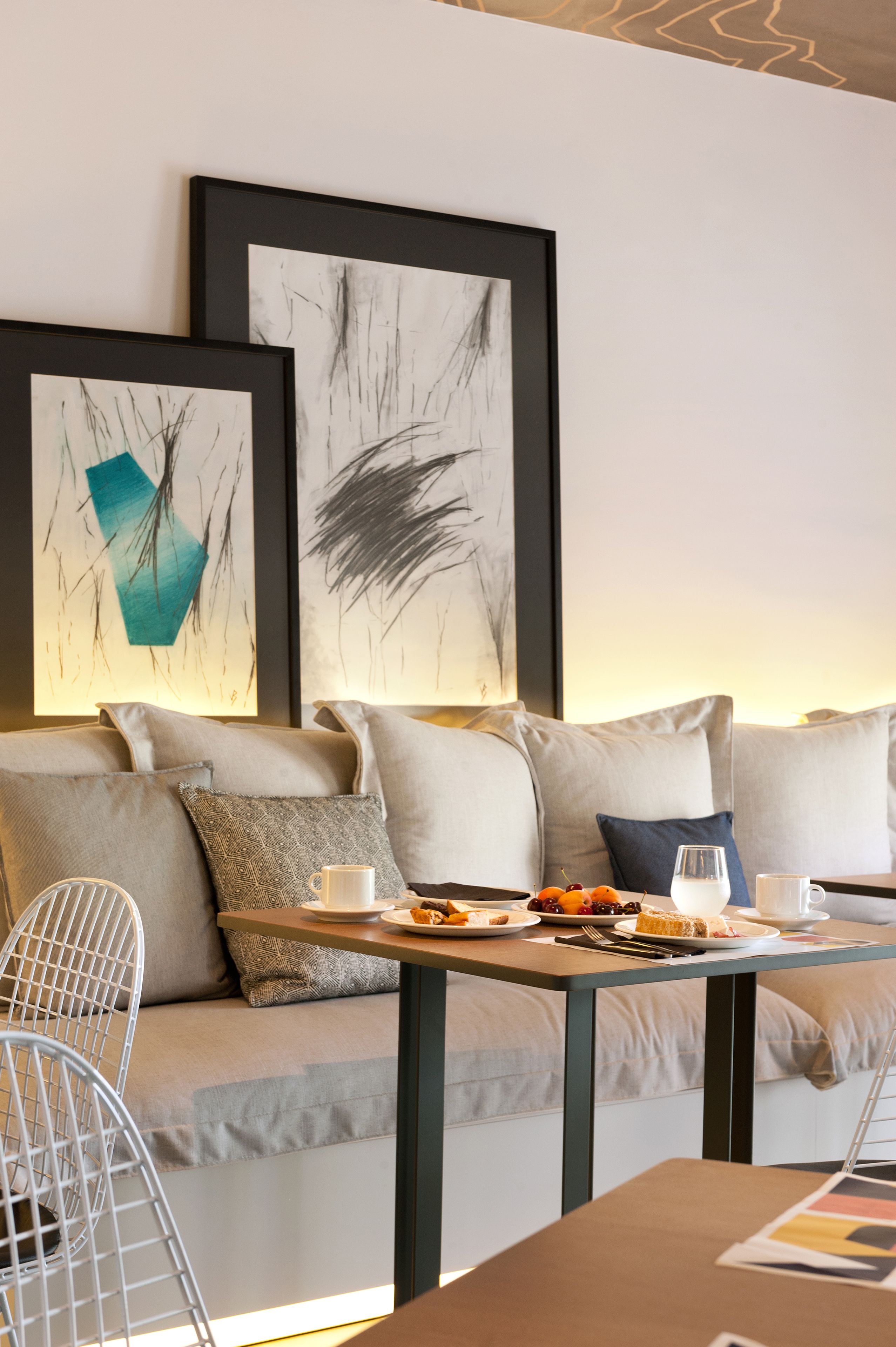 A modern living room with a sofa, a coffee table, and artwork on the wall.