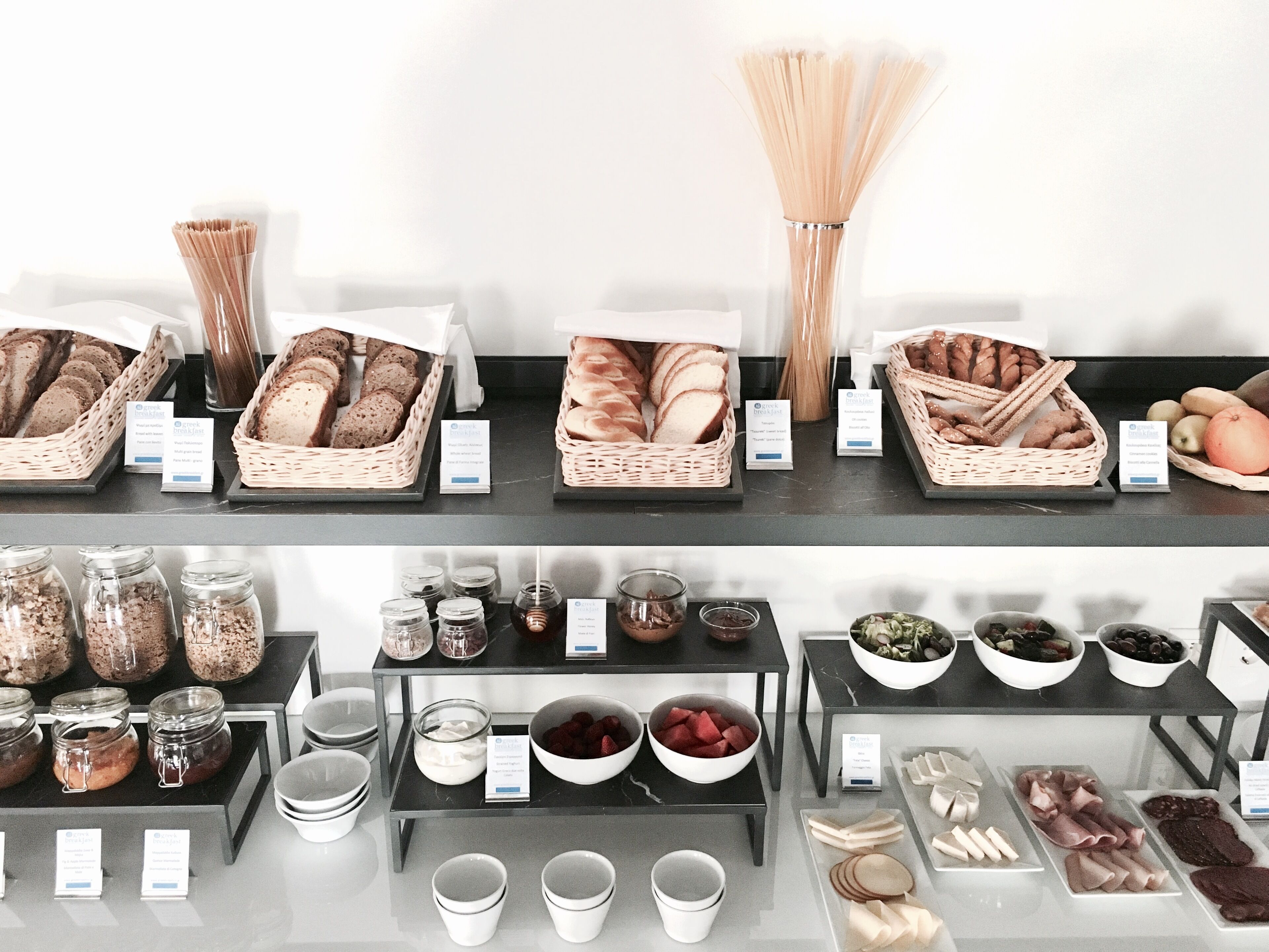 A bakery display with various breads, pastries, and jars of spreads.