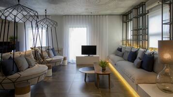 A modern living room with a sofa set, a coffee table, and hanging light fixtures.