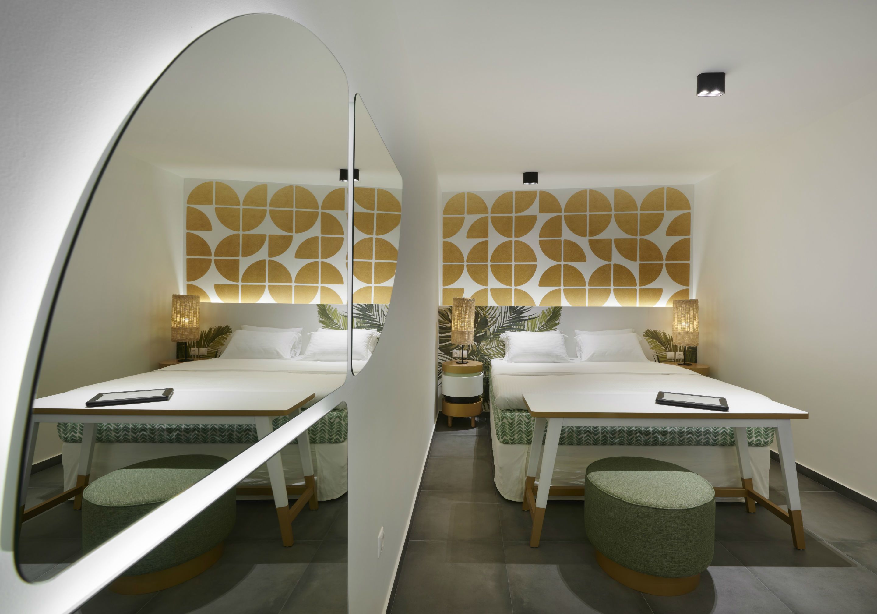 Habitación con espejo, dos camas, una mesita y un espejo.