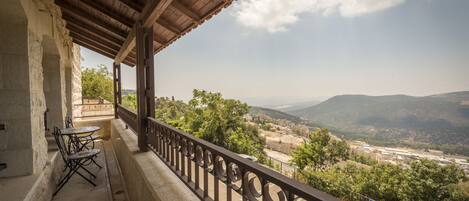 Un balcón con vista a un paisaje urbano y montañas.