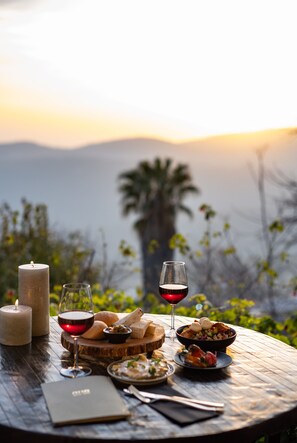 A table set with food and wine, overlooking a scenic landscape. - Ruth Zefat By Dan Hotels (Safed)