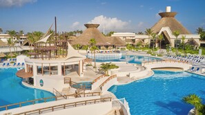 A resort with a large central pool, multiple smaller pools, and thatched-roof structures. - Bahia Principe Explore Tulum - Hyatt Inclusive Collection - All Inclusive (Akumal)
