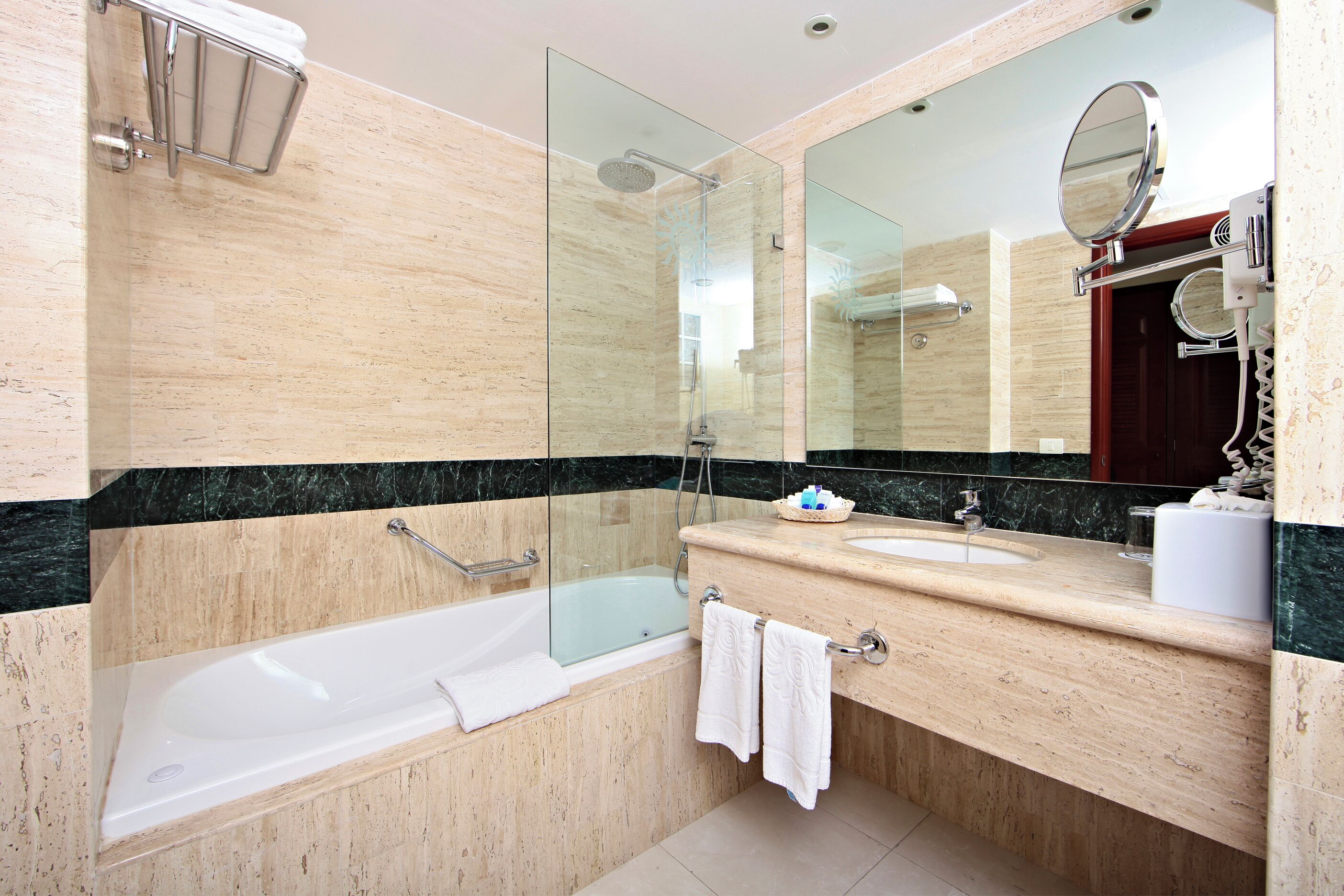 A modern bathroom with a bathtub, a glass-enclosed shower, and a vanity with a sink and mirror.