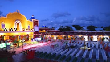 Un espacio para eventos con un escenario y filas de sillas, con la leyenda "VIVA MEXICO", lo que sugiere un lugar para una presentación o espectáculo.
