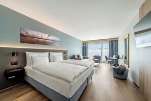 Una habitación de hotel moderna con una cama grande, mesitas de noche, un escritorio y una silla.