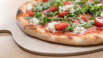 Una pizza con ingredientes sobre una tabla de madera.