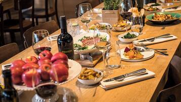 Une table à manger dressée avec différents plats, des verres à vin et une bouteille de vin.