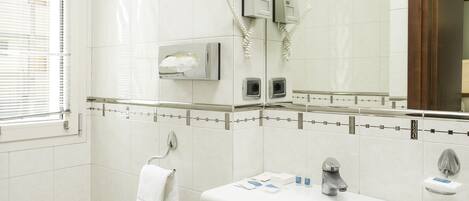 A modern bathroom with a bidet, a sink, a mirror, and a towel rack.