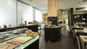 Un espace buffet proposant divers plats, un coin café et des tables où s’asseoir.