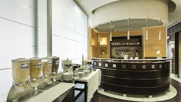 Un área de bufé con varios dispensadores de alimentos, una barra con electrodomésticos de cocina y un diseño de interiores moderno.