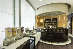 Een buffetgedeelte met diverse voedseldispensers, een toonbank met keukenapparatuur en een modern interieur.