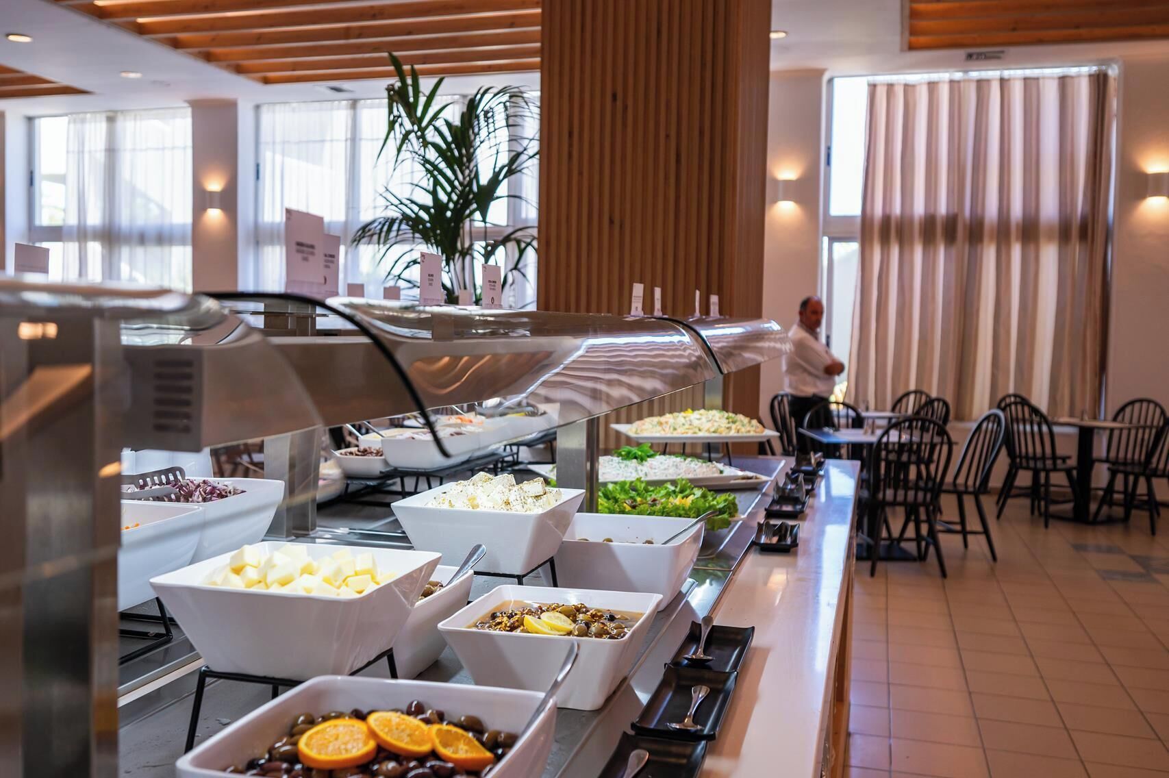 A buffet with various food options, including fruits, vegetables, and salads.