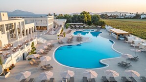 Ein Resort mit großem Pool, Sitzgelegenheiten im Freien und Bergblick.