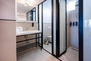 Een douche, een haardroger, handdoeken, toiletpapier