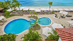 A resort with two swimming pools, beachside lounge areas, and a view of the ocean. - The House, An Autograph Collection All-Inclusive Resort - Adults Only (Paynes Bay)