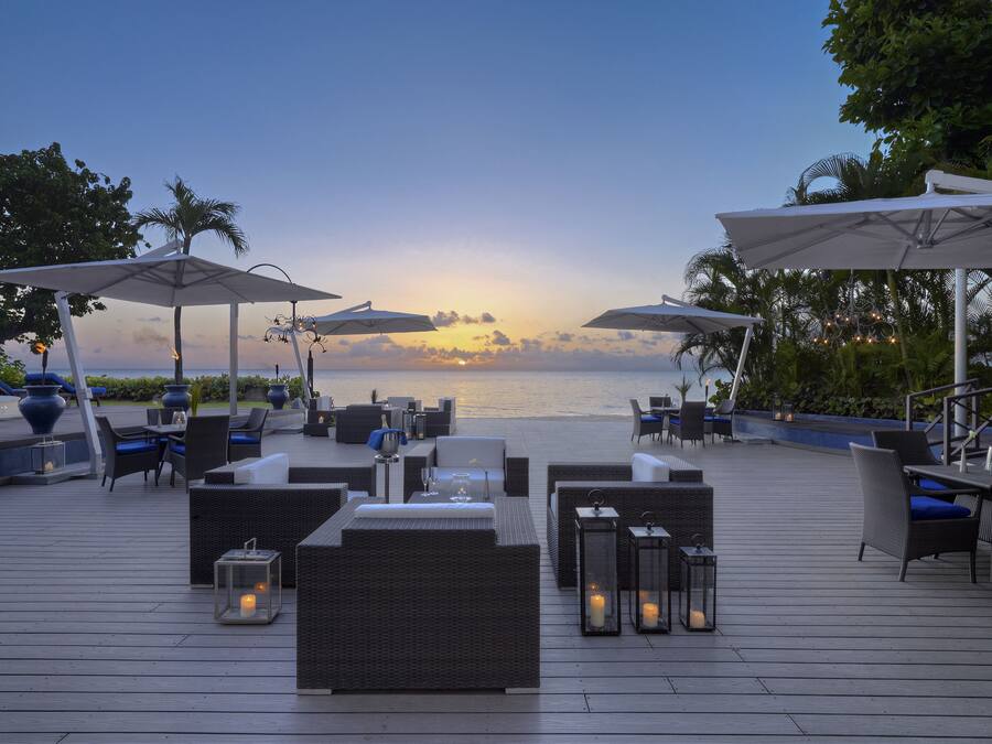 A deck with outdoor seating, umbrellas, and candles.