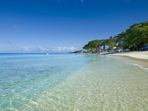En la playa, playa de arena blanca y camas de playa gratuitas