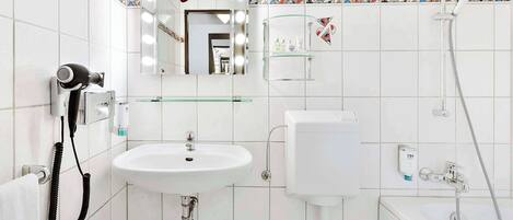 A bathroom with a white sink, mirror, and shower.