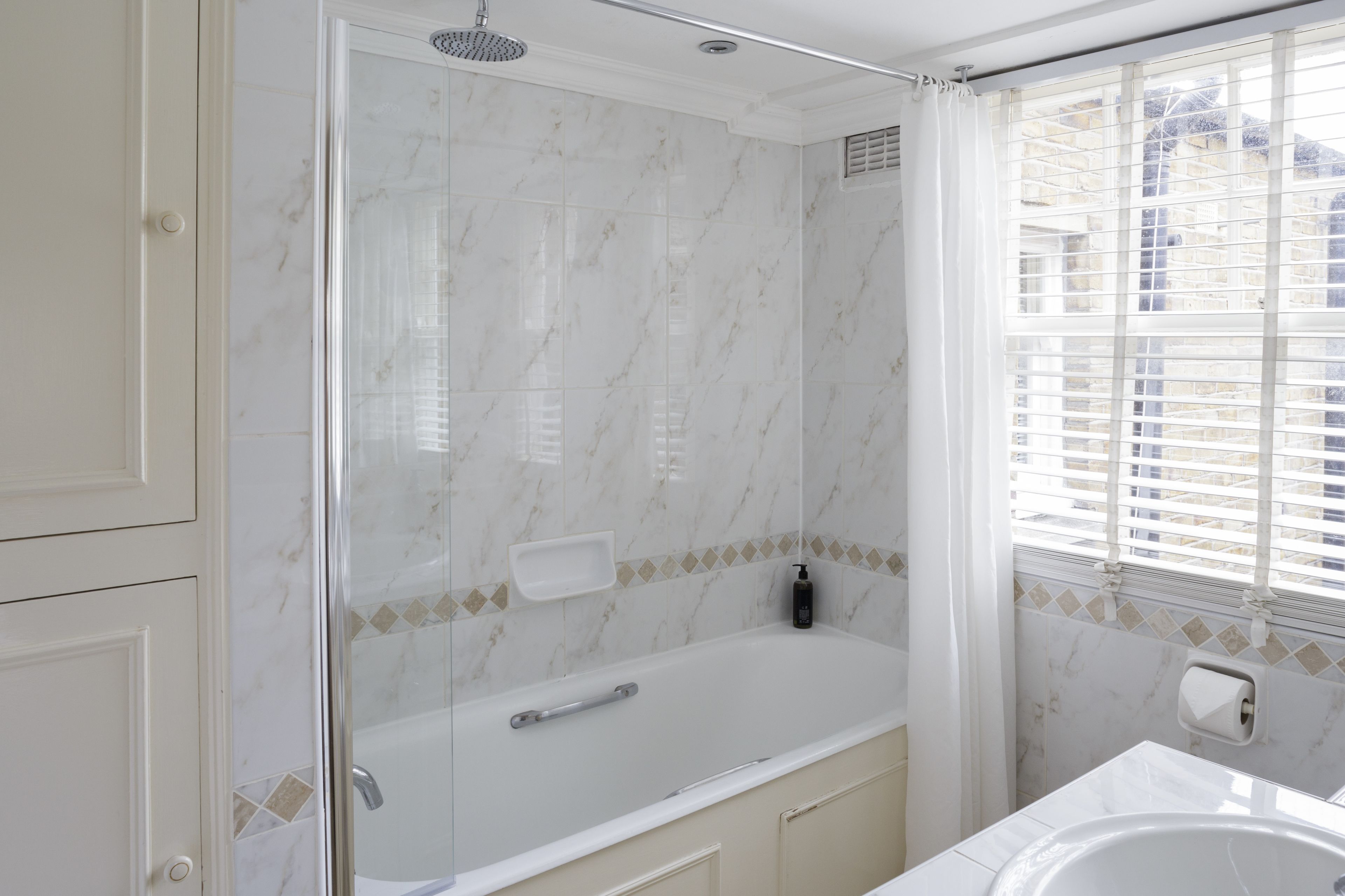 A bathroom with a shower, a bathtub, and a sink.