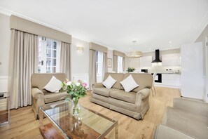 Departamento Prestigio, 3 habitaciones, cocina, vista al jardín | Área de sala de estar | Televisión de 65 pulgadas con canales vía satélite 