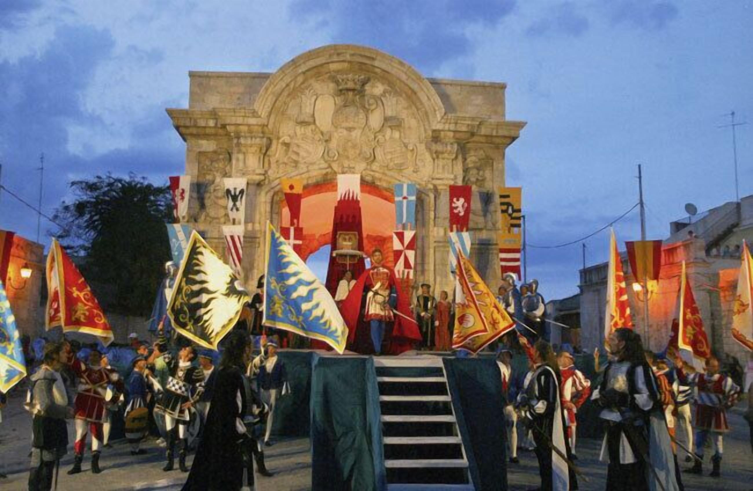 A historical reenactment with participants in period costumes and flags in front of a stone archway.