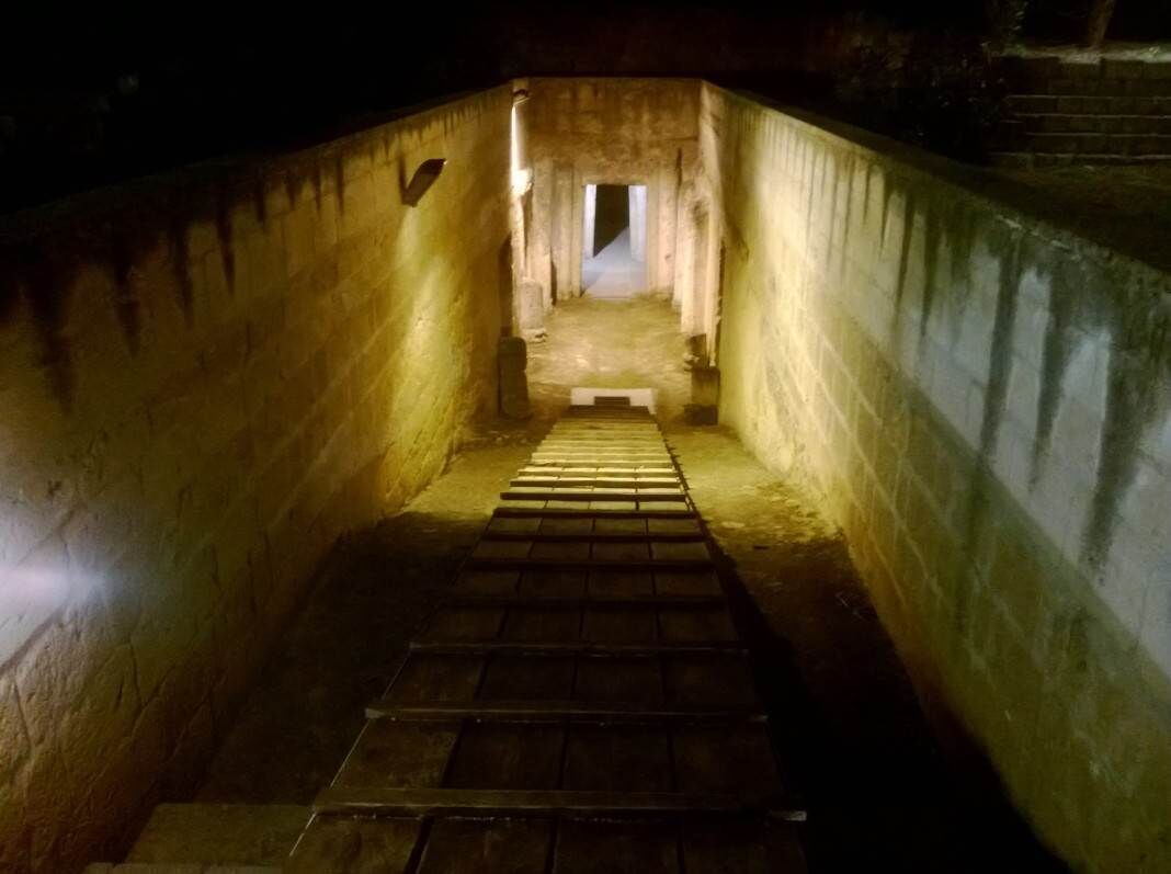 A narrow, dimly lit stairway leading to a brighter area at the top.