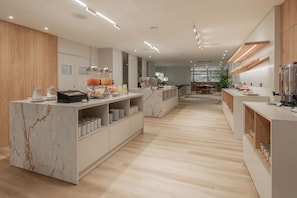A modern hotel lobby with marble reception counters, wooden paneling, and a spacious layout. - Hotel Solans Carlton (Buenos Aires)