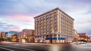 A multi-story hotel with a classic architectural design, featuring a central entrance and multiple windows on each floor. - Hampton Inn & Suites Ogden (Ogden)