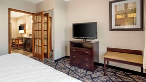 A hotel room with a bed, a television on a dresser, a desk with a chair, and a framed picture on the wall. - Best Western Plus Hobby Airport Inn & Suites (Houston)