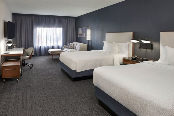A hotel room with two beds, a desk, a chair, a TV, and a large window with curtains. - Courtyard by Marriott Toronto Markham (Markham)