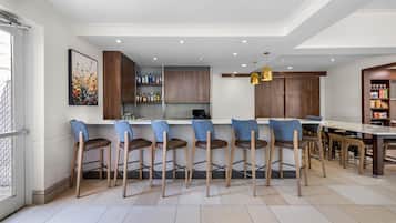 Una cocina moderna con taburetes de bar, una mesa de comedor y una isla de cocina.
