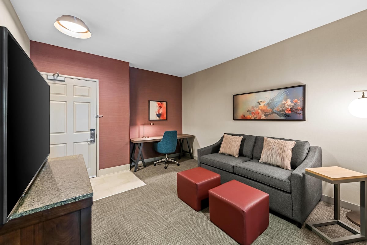 Escritorio, cortinas blackout y tabla de planchar con plancha