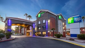 Un hotel Holiday Inn Express con diseño moderno, que presenta una entrada destacada y señalización bien iluminada.