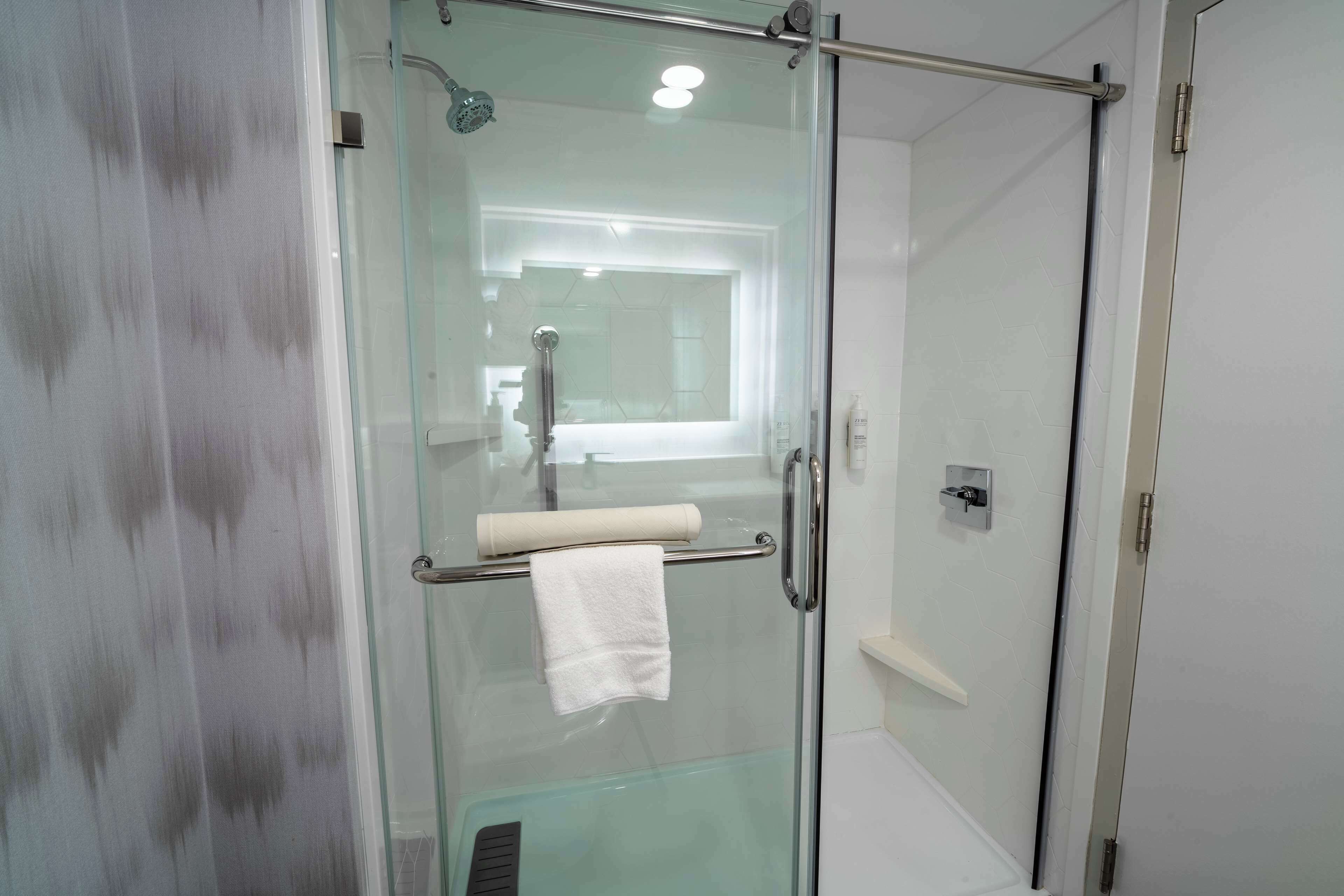 Eine Duschkabine mit Handtuchhalter und sichtbarer Dusche.