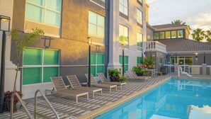 A pool area with lounge chairs and a staircase leading to a building. - Hampton Inn St. Augustine Downtown Historic District (St. Augustine)