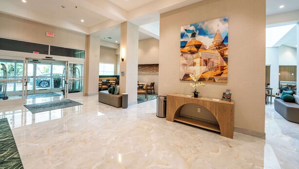A spacious lobby with a marble floor, a reception desk, and a large wall mural. - Hampton Inn St. Augustine Downtown Historic District (St. Augustine)