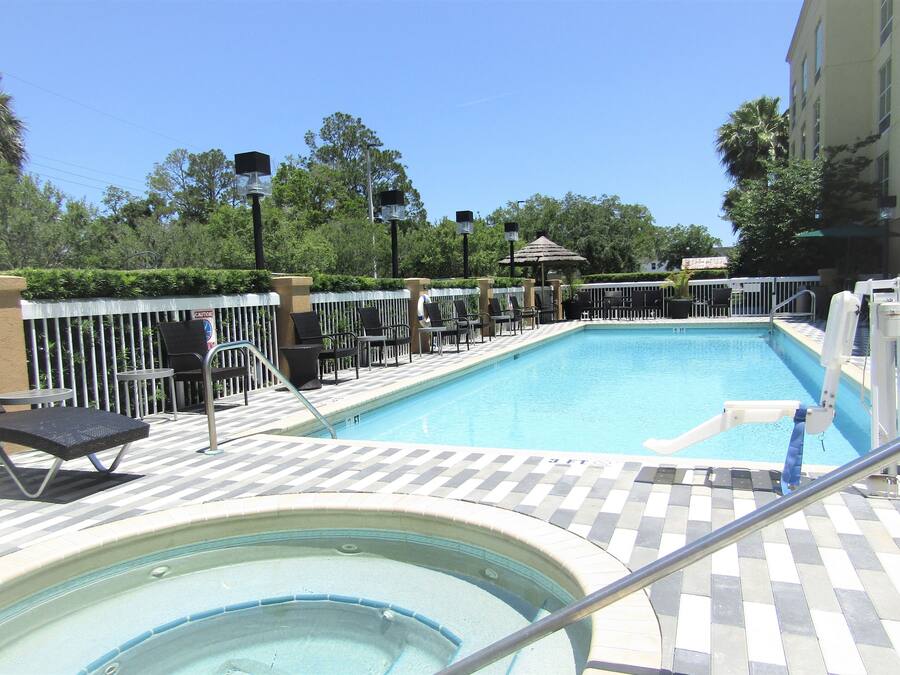 A pool area with lounge chairs and a hot tub.
