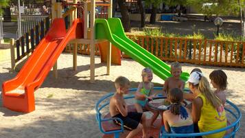 A playground with slides and a merry-go-round.