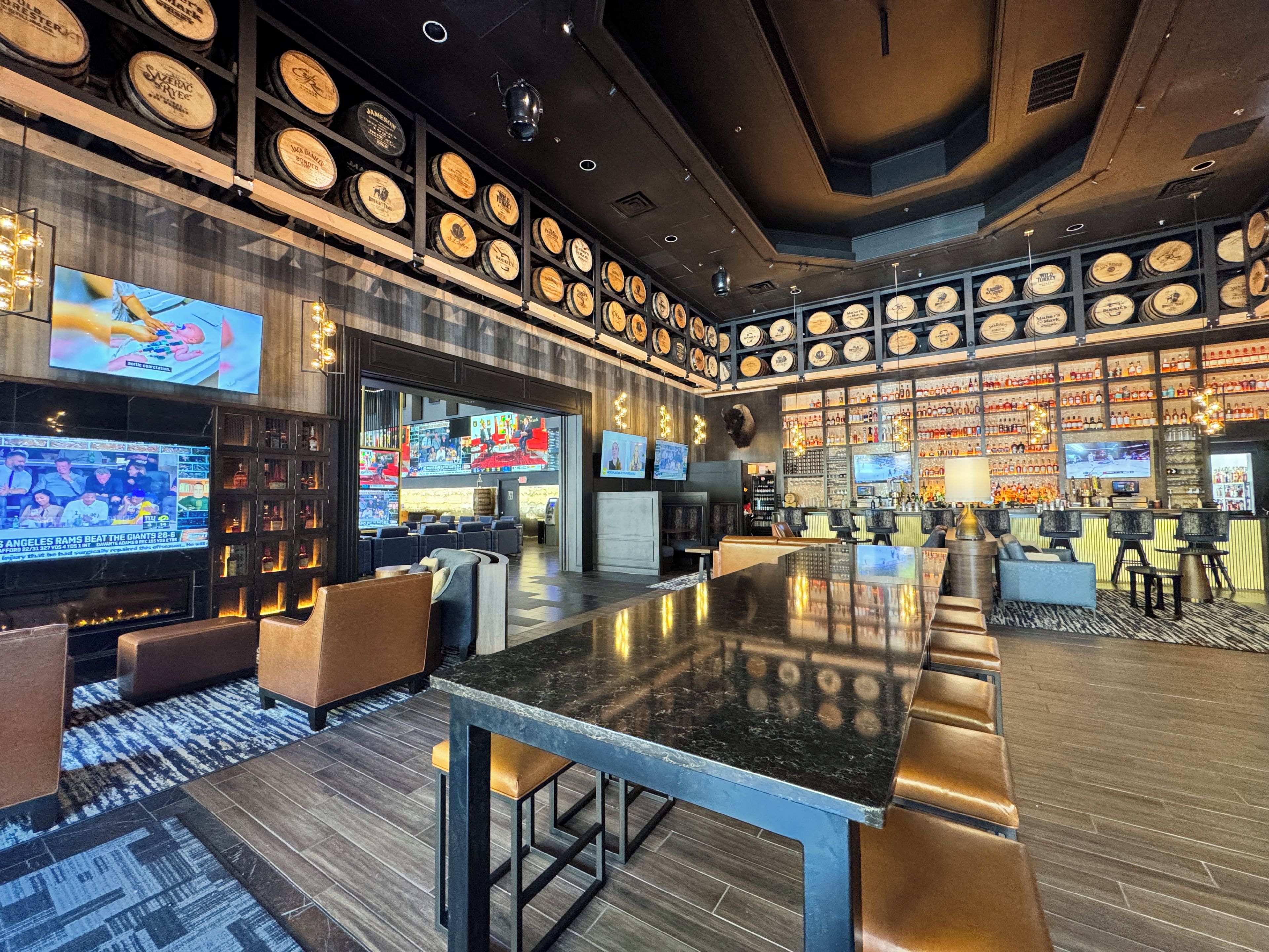 A bar area with a long counter, multiple seating options, and a wall decorated with circular plaques.