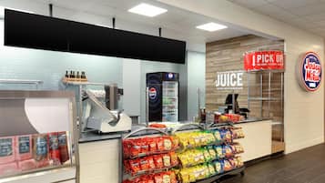 A deli counter with a variety of packaged meats, a Pepsi refrigerator, and a sign for 'I PICK UP'.