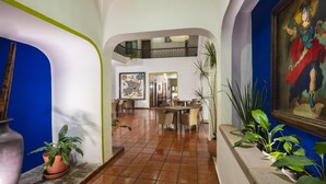 A spacious lobby with a tiled floor, a central seating area, and a staircase leading to an upper level. - Hotel Vista Express Morelia By Arriva Hospitality Group (Morelia)