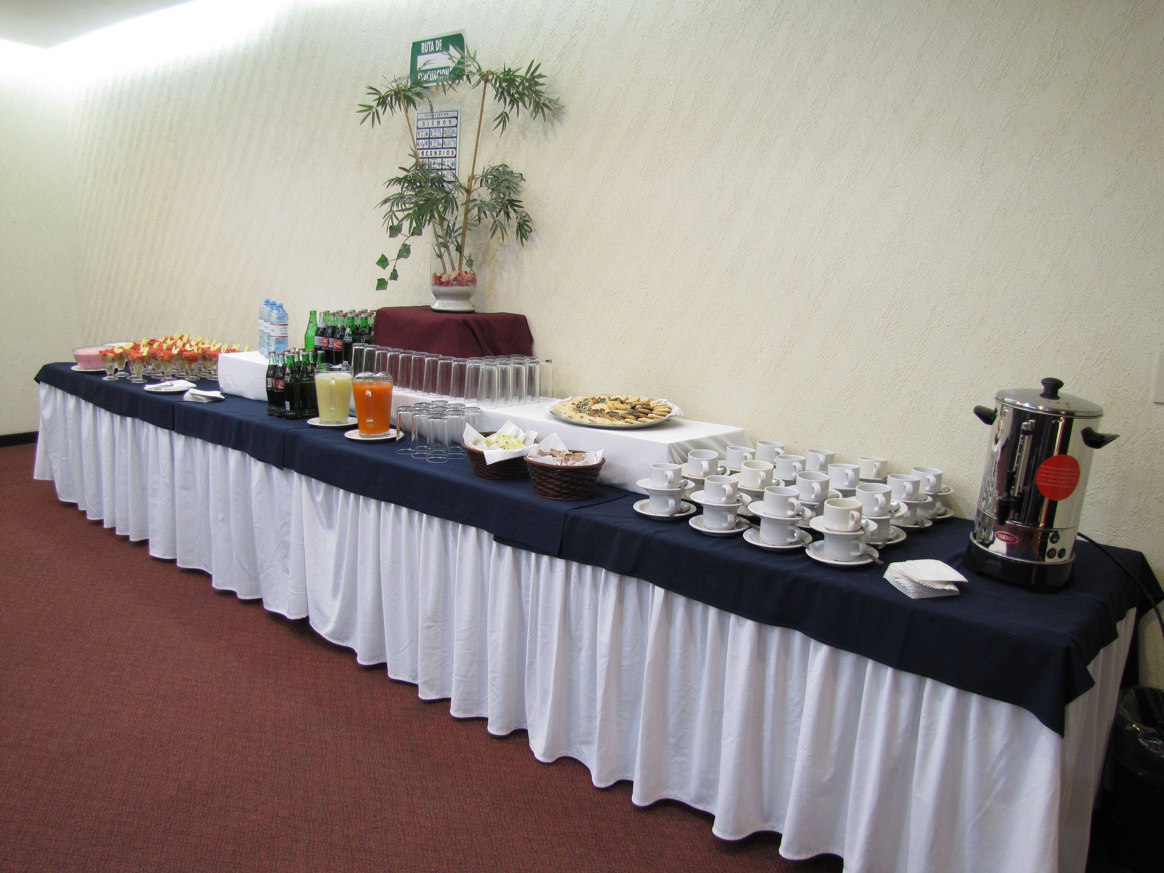 Une table de buffet proposant divers plats, boissons et une machine à café.