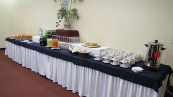 Une table de buffet proposant divers plats, boissons et une machine à café.