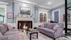 A living room with a fireplace, two sofas, a coffee table, and a large window. - Natural Bridge Hotel, Trademark Collection by Wyndham (Natural Bridge)